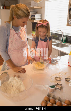 Vue avant de la mère heureuse avec sa fille faire des biscuits dans la cuisine à la maison Banque D'Images