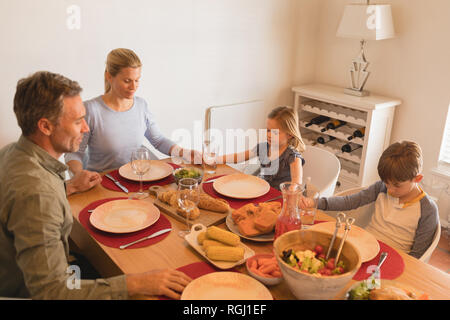 Portrait de famille prier avant d'avoir de la nourriture sur table à manger à la maison Banque D'Images