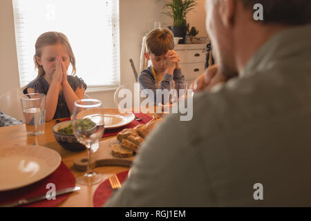 Plus d'épaule de prier en famille avant d'avoir de la nourriture sur table à manger à la maison Banque D'Images