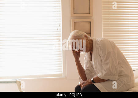 Déprimé senior woman sitting in bedroom Banque D'Images