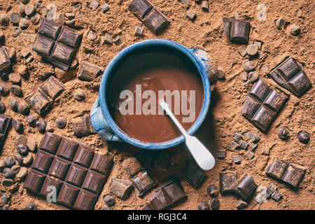 Le chocolat fondu dans un bol entouré de morceaux de chocolat et de poudre de cacao Banque D'Images