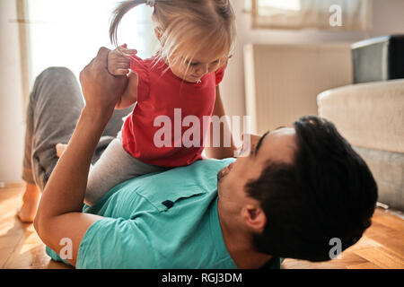 Petite fille jouant avec son père à la maison Banque D'Images