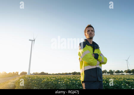 Permanent ingénieur dans un champ à une éolienne Banque D'Images