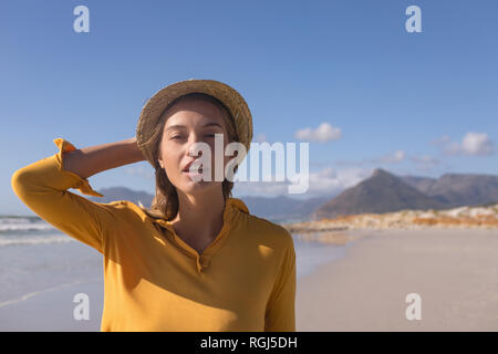 Woman wearing hat standing on the beach Banque D'Images
