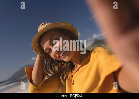 Woman wearing hat détente sur la plage Banque D'Images