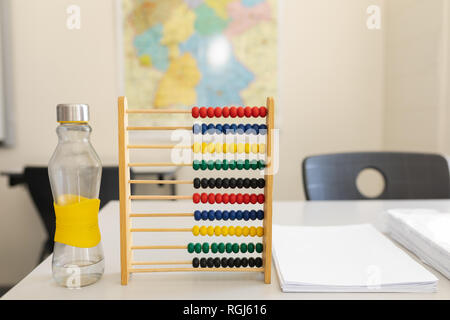 Une bouteille d'eau, Abacus et bande de papier sur le bureau à l'école Banque D'Images
