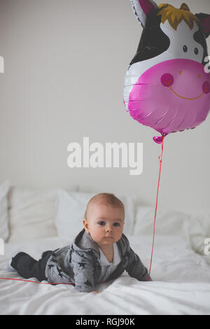 Petit bébé garçon aux grands ballon, assis sur le plancher à la maison Banque D'Images