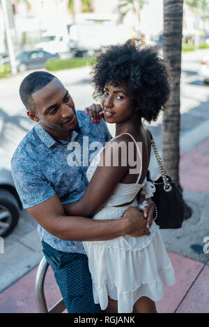 USA, Florida, Miami Beach, smiling young couple embracing dans la ville Banque D'Images