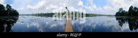 Un étroit chemin à pied soulevé en bois traverse un lac artificiel du Neak Pean temple , à Ankor Wat, au Cambodge. Banque D'Images