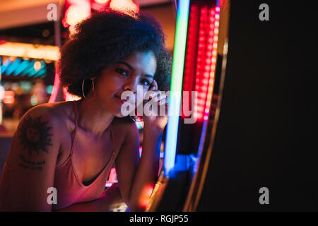 USA, Nevada, Las Vegas, portrait de jeune femme à la machine à sous dans un casino Banque D'Images