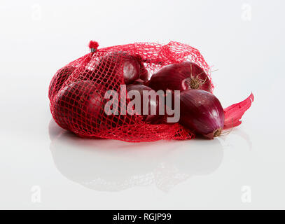 Net avec oignons rouges sur fond blanc Banque D'Images