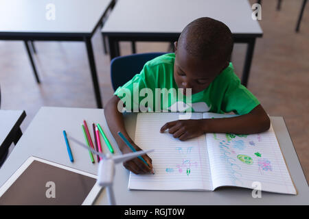 Portrait de dessin d'écolier sur livre à 24 en classe d'école primaire Banque D'Images