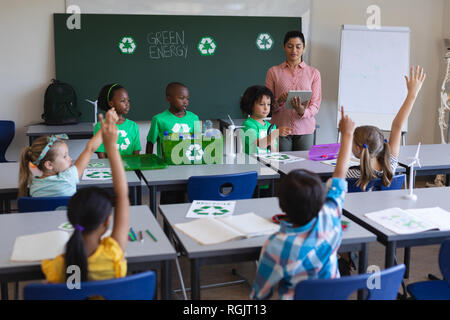 Vue avant du schoolkids étudier sur green energy et recycler à 24 en classe d'école primaire Banque D'Images