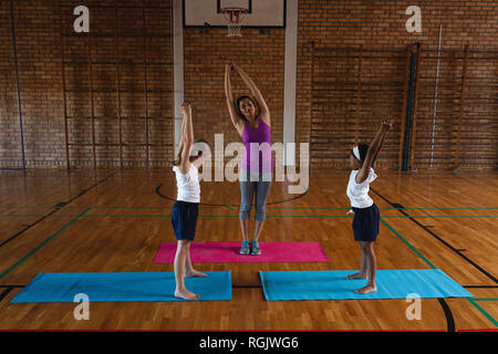 Vue avant du jeune professeur de yoga l'enseignement du yoga à l'école les enfants à l'école Banque D'Images