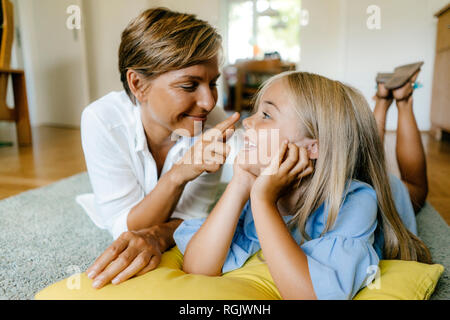 Heureuse mère et fille se trouvant sur le plancher à la maison Banque D'Images