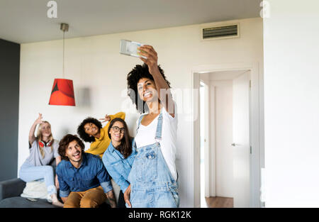 Cheerful friends prenant une à la maison selfies Banque D'Images
