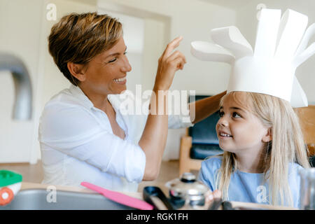 Heureuse mère et fille jouer à la maison mettre sur Chef's Hat Banque D'Images