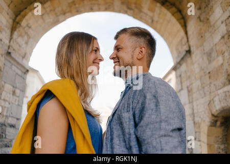 Young couple smiling at each other dans la ville Banque D'Images