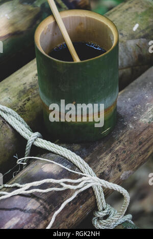 Faites de bambou bio frais tasse et cuillère rempli de délicieux café chaud sur un banc dans la jungle en Thaïlande. L'écotourisme Banque D'Images