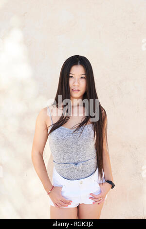 Portrait of pretty asian girl looking at camera avec de longs cheveux noirs Banque D'Images