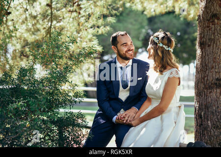 Happy young couple holding hands in a park Banque D'Images
