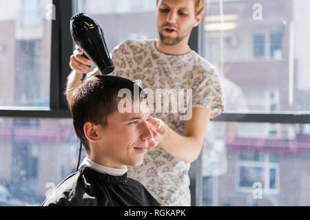 Le séchage, Men's Styling des cheveux dans un salon de beauté. Banque D'Images