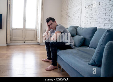 Portrait de jeune homme déprimé d'abattage et désespérés de pleurer seul dans canapé accueil douleur émotionnelle la souffrance et le malheur. Les gens de cœur brisé, Bull Banque D'Images