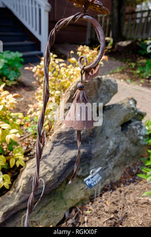 Antique brown décoratif en fer forgé jardin bell. Jardin Devant avec tronc d'arbre, arbustes et les escaliers en arrière-plan. Chestnut Square Historic Village, Banque D'Images