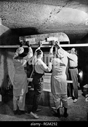 Howard Carter (deuxième à gauche) qui a découvert la tombe de Toutankhamon dans la Vallée des Rois, Louxor, Egypte. Novembre 1922 avec deux travailleurs égyptiens et Arthur Callender de travailler à l'intérieur de la tombe. À partir de l'image numérisée dans les archives de presse - Service Portrait Portrait Presse (anciennement Bureau). Banque D'Images