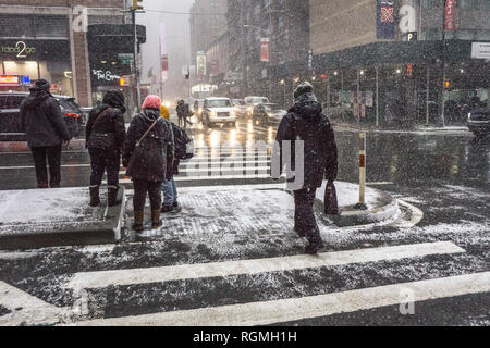 New York, USA le 30 janvier 2019 ; voir au coin de la 8e Avenue et 49e rue, en tant que piétons replier sur au feu de circulation contre brève poussée par le vent féroce de bourrasques de neige l'après-midi. En général les New-yorkais ne pas porter de fourrure manteaux ou dans la rue quand il neige, préférant les parkas (qui gratuitement les jambes) avec les capots portés par-dessus regarder caps. Les manteaux sont pour Wall Street et les fourrures pour marcher une courte distance entre le véhicule et bâtiment. Credit : Dorothy Alexander/Alamy Live News Banque D'Images