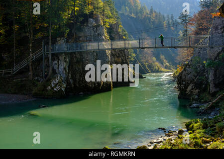 Autriche, Tyrol, randonneur sur pont suspendu à la Tiroler Ache en automne à Banque D'Images