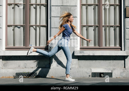 Pays-bas, Maastricht, happy blonde jeune femme tournant le long bâtiment de la ville Banque D'Images