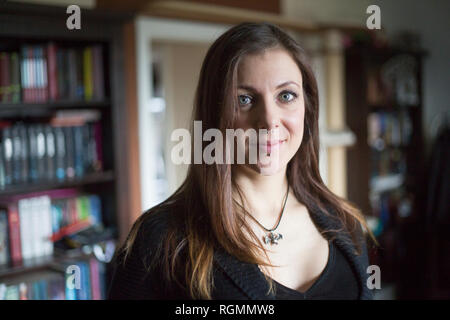 Portrait of smiling woman with piercings à la maison Banque D'Images