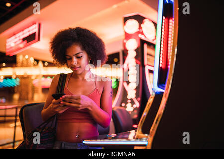 USA, Nevada, Las Vegas, young woman using cell phone dans un casino Banque D'Images