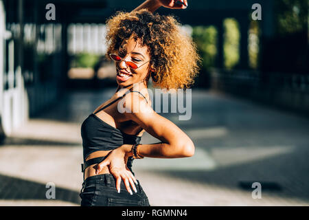 Portrait of young woman dancing outdoors Banque D'Images