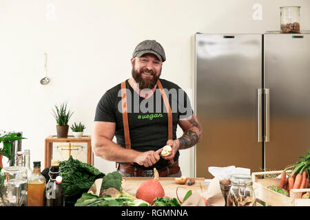 Man slicing vegan pommes dans sa cuisine Banque D'Images
