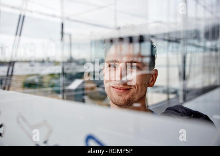 Portrait of smiling young man à l'aéroport à la fenêtre de Banque D'Images