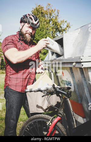 Portrait du cycliste le recyclage des déchets papier dans le bank Banque D'Images