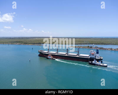 Navire vraquier aérienne sur la rivière Burnett d'amarrer à la borne du sucre avec l'aide de deux remorqueurs Australie Queensland Bundaberg Port Banque D'Images