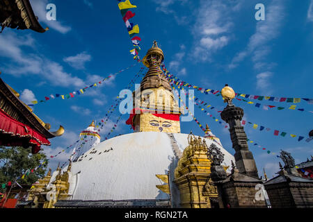 Le grand stupa de Swayambhunath avec battement de drapeaux de prières, de petits temples et sculptures ci-dessous Banque D'Images