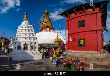 Le grand stupa de Swayambhunath avec battement de drapeaux de prières, de petits temples et sculptures ci-dessous Banque D'Images