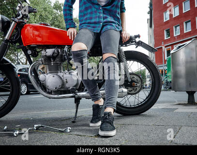 Close-up of young woman on motorcycle Banque D'Images