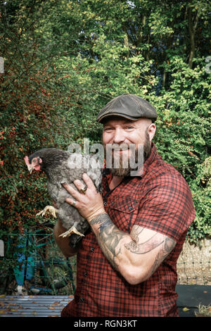 L'homme dans son propre jardin, l'homme avec free range chicken Banque D'Images