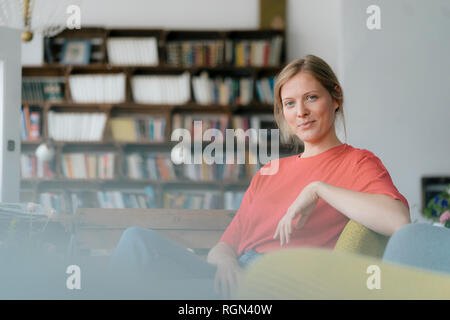 Portrait of smiling young woman sitting in a cafe Banque D'Images