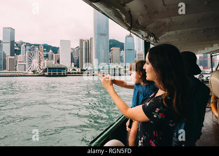 La Chine, Hong Kong, mère et fille de traverser la rivière en ferry de Kowloon à Hong Kong Island Banque D'Images