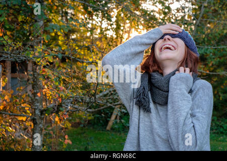 Laughing woman wearing hat and scarf laineux à l'automne Banque D'Images