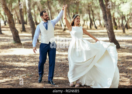 Happy young couple dansant ensemble dans une forêt de pins Banque D'Images