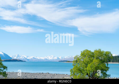 Les nuages blancs drit à travers ciel bleu au-dessus du lac Tekapo magnifique paysage et enneigés des Alpes du sud lointain Banque D'Images