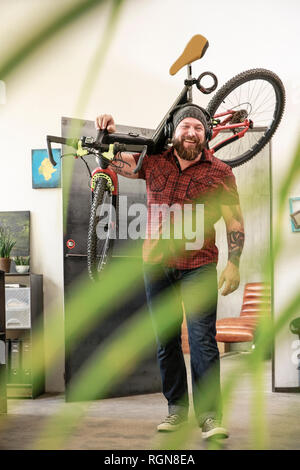 Happy man wearing headphones transportant location in office Banque D'Images