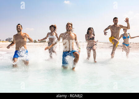 Groupe d'amis s'amuser sur la plage, courir dans l'eau Banque D'Images